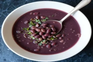 Vibrant Bowl of Purple Black Bean Soup with Fresh Garnish